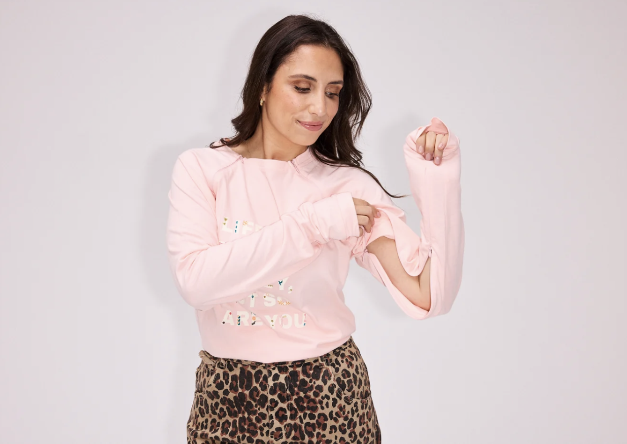 The "Life Is Tough" Long Sleeve T-shirt in pale pink with arm and chest access shown with sleeve zip openings..